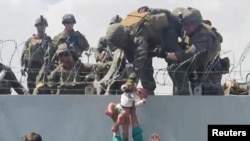 Кабул аба майданында ооганстандык качкындар наристесин чек арадан өткөрүүдө. 