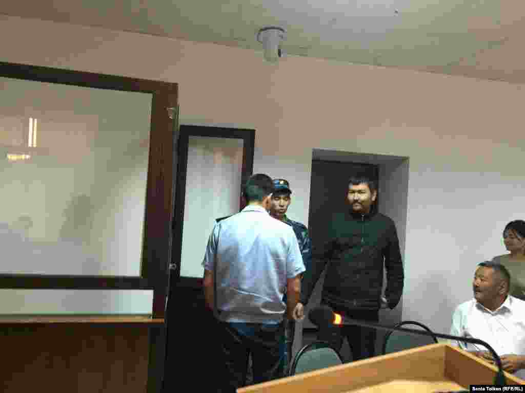 Находящегося под стражей гражданского активиста Талгата Аяна полицейские доставили в зал суда.&nbsp;