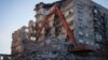 Workers dismantle a section of a building in Magnitogorsk hit by a blast on December 31, 2018.