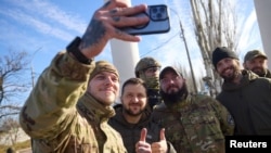 Ukrainian President Volodymyr Zelenskiy poses with soldiers during a visit to newly liberated Kherson on November 14.