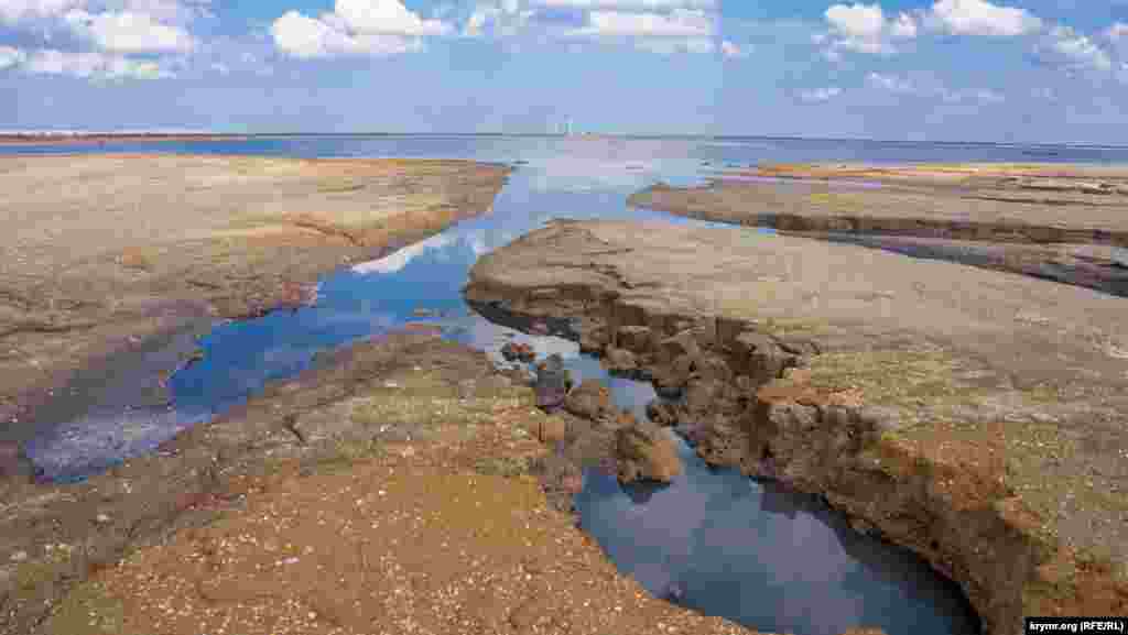 Вода збереглася лише у східній частині озера. На передньому плані &ndash; пташині &laquo;ванни&raquo;. Вдалині видніються вітрогенератори функціонуючої Східно-Кримської вітряної електростанції