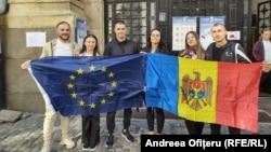 Грамадзяне Малдовы ў Румыніі трымаюць эўрапейскія і малдоўскія сьцягі на выбарчым участку дыяспары ў Бухарэсьце. Ілюстрацыйнае фота