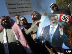 Күвәйт депутаты Вәлид Табтабай протест чарасында Русия президенты Дмитрий Медведев сурәтен яндыра