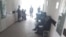 Пациенты Медицинского объединения в городе Кувасай стоят в очереди, чтобы попасть на прием к врачу.