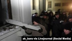 Архіўнае фота. Меркавана, Уладзімер Кондрусь б'е шкло Дома ўраду падчас акцыі пратэсту на плошчы Незалежнасьці пасьля прэзыдэнцкіх выбараў 2010 году