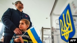 Украинские граждане голосуют на выборах в Верховную Раду на избирательном участке в Минске. 26 октября 2014 года. 