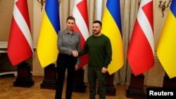 Прем’єр-міністерка Данії Метте Фредеріксен і президент України Володимир Зеленський тиснуть руки під час зустрічі у Палаці Потоцьких у Львові. 23 лютого 2024 року