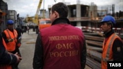 Орусиянын Миграция кайгуул кызматынын өкүлү курулушта иштеген мигранттар менен. Иллюстрациялык сүрөт.