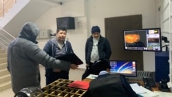 Гражданский активист Дулат Агадил (второй слева) в отделе полиции Целиноградского района. Село Акмол, Акмолинская область, 15 ноября 2019 года.