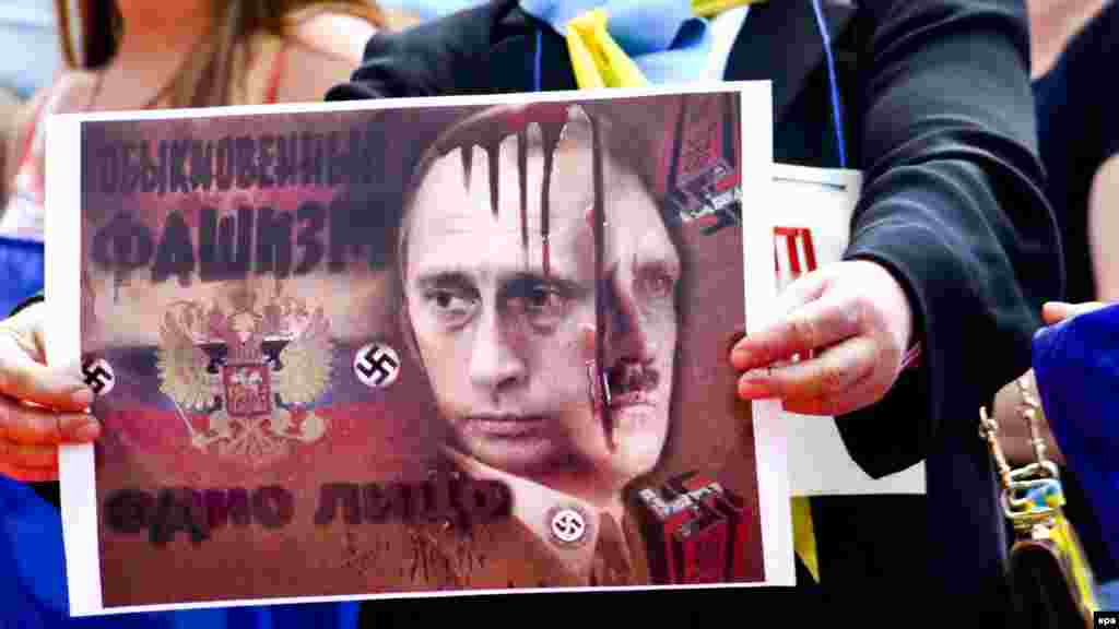 Плакат учасниці протесту проти агресії Росії напередодні візиту до Італії російського президента Володимира Путіна. Мілан, 9 червня 2015 року