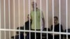 Britons Aiden Aslin and Shaun Pinner and Moroccan Brahim Saadoun appear in a courtroom cage at a location said to be Donetsk.