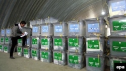 Сотрудник Независимой избирательной комиссии Афганистана (IEC) возле урн с бюллетенями, привезенными с избирательных участков Кабула. 7 апреля 2014 года.  