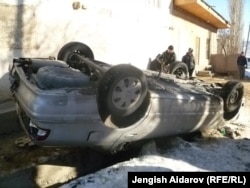 Перевернутая машина в кыргызском селе Чарбак после столкновений с жителями анклава Сох. 7 января 2013 года.