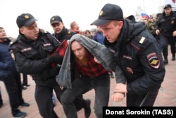 Police detain a man during an unauthorized rally in Yekaterinburg on October 7.