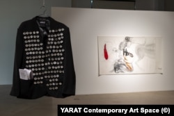 Фрагмент инсталляции Наталии Васадзе “Родина” (2025) на фоне работы Влады Ралко “Никто” (2023)