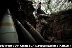 Військовослужбовець 24-ї ОМБр ЗСУ імені короля Данила несе снаряд для самохідної гаубиці M109 на позиції поблизу Часового Яру. Донеччина, 14 червня 2025 року