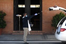 Священник читает молитву у автомобиля с гробом умершего от коронавируса. Испания, март 2020 года.