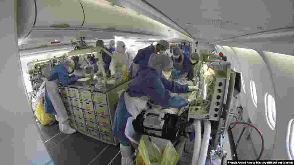 Учактын ичинде бейтапты дарылап жаткан догдурлар. Франция. 27-март, 2020-жыл.&nbsp;