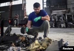 Працівник одного з підприємств Львова оглядає рештки російського безпілотника. Україна, 10 вересня 2025 року