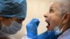 A medic takes a swab from a woman at a medical facility in Moscow to test for the coronavirus on July 16.