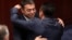 Macedonian Foreign Minister Nikola Dimitrov (left) and Prime Minister Zoran Zeav congratulate each other after the Macedonian parliament first ratified the deal in Skopje on June 20.