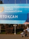 Женщина с ребенком проходит под баннером с изображением Нурсултана Назарбаева, установленным перед Днем первого президента Казахстана. Алматы, 30 ноября 2015 года