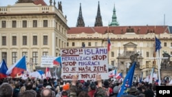 Участники антимусульманской акции держат плакат с надписью на чешском языке: «Остановите ислам и остановите Меркель». Прага, 6 февраля 2016 года.