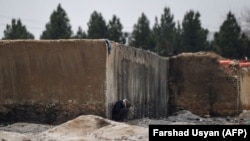 یک فرد معتاد در حال دود کردن تریاک در شهر مزارشریف (تصویر آرشیف)