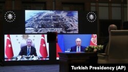Turkish Recep Tayyip Erdogan (left) and Russian President Vladimir Putin speak during a ceremony as they remotely inaugurate construction at Turkey's Akkuyu power plant on March 10.