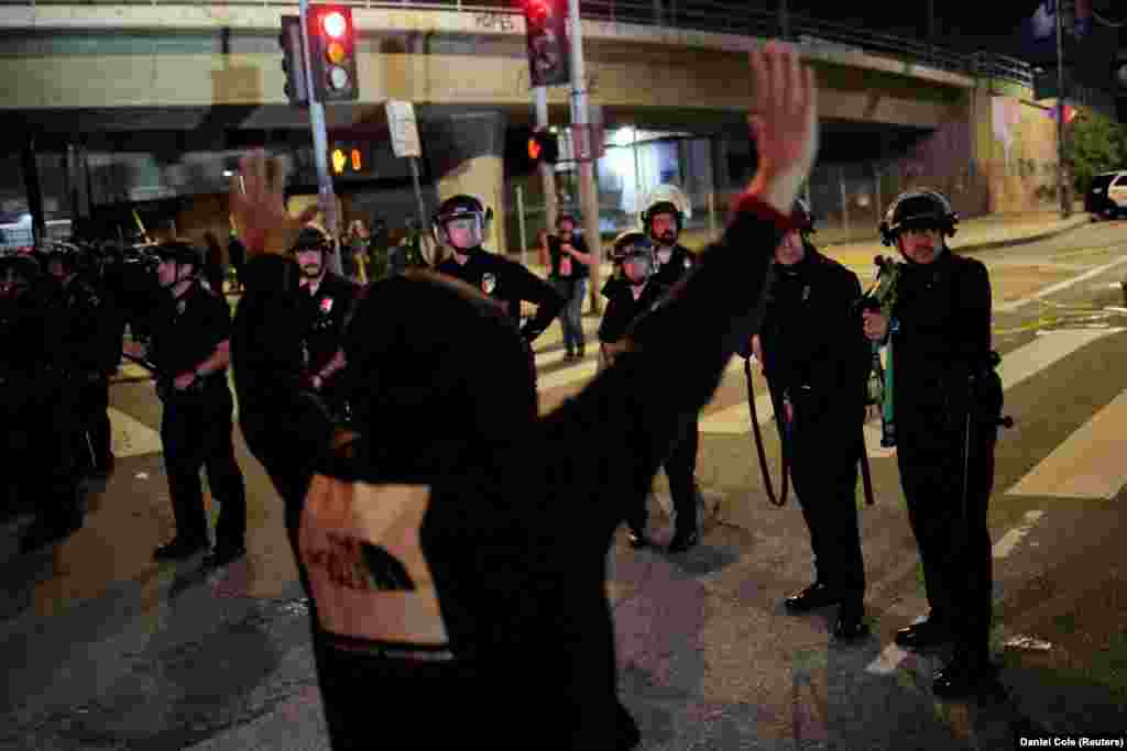 Демонстрант з піднятими руками стоїть навпроти правоохоронців під час акції протесту «Ні королям» проти політики президента США Дональда Трампа. Лос-Анджелес, Каліфорнія, США, 18 жовтня 2025 року