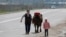 KAZAKHSTAN -- A woman and a child walk with a cow along a street during a lockdown imposed by the government as part of state of emergency to prevent the spread of the coronavirus disease (COVID-19) in Almaty, April 14, 2020