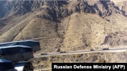 NAGORNO-KARABAKH -- A Russian military helicopter Mi-8 patrols military vehicles of the Russian peacekeeping forces as they move on the road toward Stepanakert, November 14, 2020