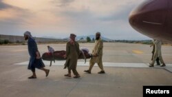 مردم در اول سپتمبر ۲۰۲۵ جسد یک قربانی زلزله را به سوی امبولانس در میدان هوایی شهر جلال آباد انتقال می‌دهند.