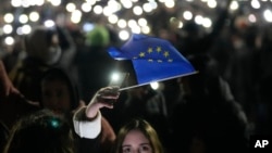 Протестувальниця тримає прапор ЄС під час мітингу біля будівлі парламенту Грузії, Тбілісі, 4 грудня 2024 року