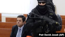 Marian Kocner sits surrounded by armed police officers in a courtroom in Pezinok on December 19.