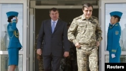 Женщины-военослужащие казахстанской армии приветствуют министров обороны Казахстана и России Адильбека Джаксыбекова и Анатолия Сердюкова во время учений на военной базе Матыбулак. Алматинская область, 24 сентября 2010 года.