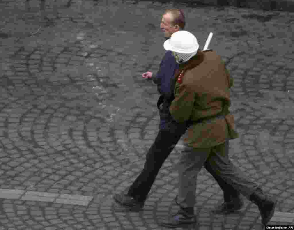 Офицер полиции задерживает протестующих во время митинга 15 января 1989