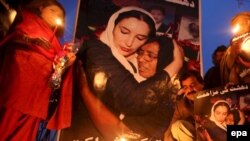 Ҷонибдорони Беназир Бҳутто дар Лоҳур дар назди расми марҳум шамъ равшан мекунанд