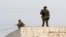 Kazakhstan - In this photo taken Saturday, Dec. 17, 2011, armed Kazakh soldiers stand on a top of a building in center of Zhanaozen, Kazakhstan. Kazakhstan President Nursultan Nazarbayev on Saturday imposed a three-week state of emergency in an oil town w