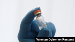 UKRAINE -- A medical worker shows a vial with the Chinese-developed CoronaVac vaccine against the coronavirus disease (COVID-19) at a clinic in Kyiv, April 15, 2021