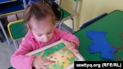 Ребенок играет в развивающие игры в центре "Капитошка". Темиртау, 26 марта 2015 года.