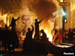 "Окленди ээле!" деп аталган демонстрация учурунда анын катышуучулары байрактарды булгалап, автомобилдин дөңгөлөктөрүн өрттөшүүдө. Калифорния, Окленд. 3-ноябрь 2011