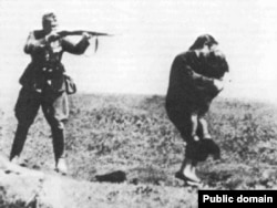 Фашистский солдат расстреливает женщину с ребенком в Бабьем Яре, на месте массового убийства вблизи Киева. Иллюстративное фото.