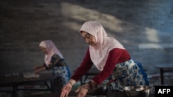 Кытайдагы уйгурлар кечки тамакка даярданууда.