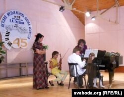 На сцэне Стывэн Прутсман, юная скрыпачка Мішэль Бушкова і яе тата Яўген Бушкоў, кіраўнік Дзяржаўнага камэрнага аркестру Рэспублікі Беларусь