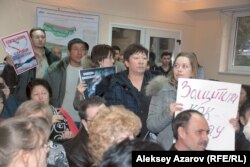 Защитники урочища Кокжайляу держат в руках плакаты. Алматы, 19 января 2015 года.