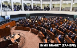 Президент України Володимир Зеленський (на екрані) під час звернення через відеозв'язок до парламенту Фінляндії. Гельсінкі, 8 квітня 2022 року