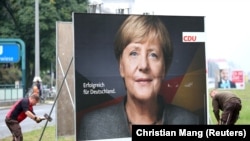 Ангела Меркелдин шайлоо маалындагы Берлиндеги көрнөк-жарнактарынын бири.