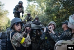 Українські військовослужбовці несуть пораненого під час боїв біля Іловайська. 10 серпня 2014 року