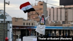 Майрамдык салтанат учурунда Багдаддагы Тахрир аянтында Ирактын желегин кармап турган адам. 10-декабрь, 2017-жыл.